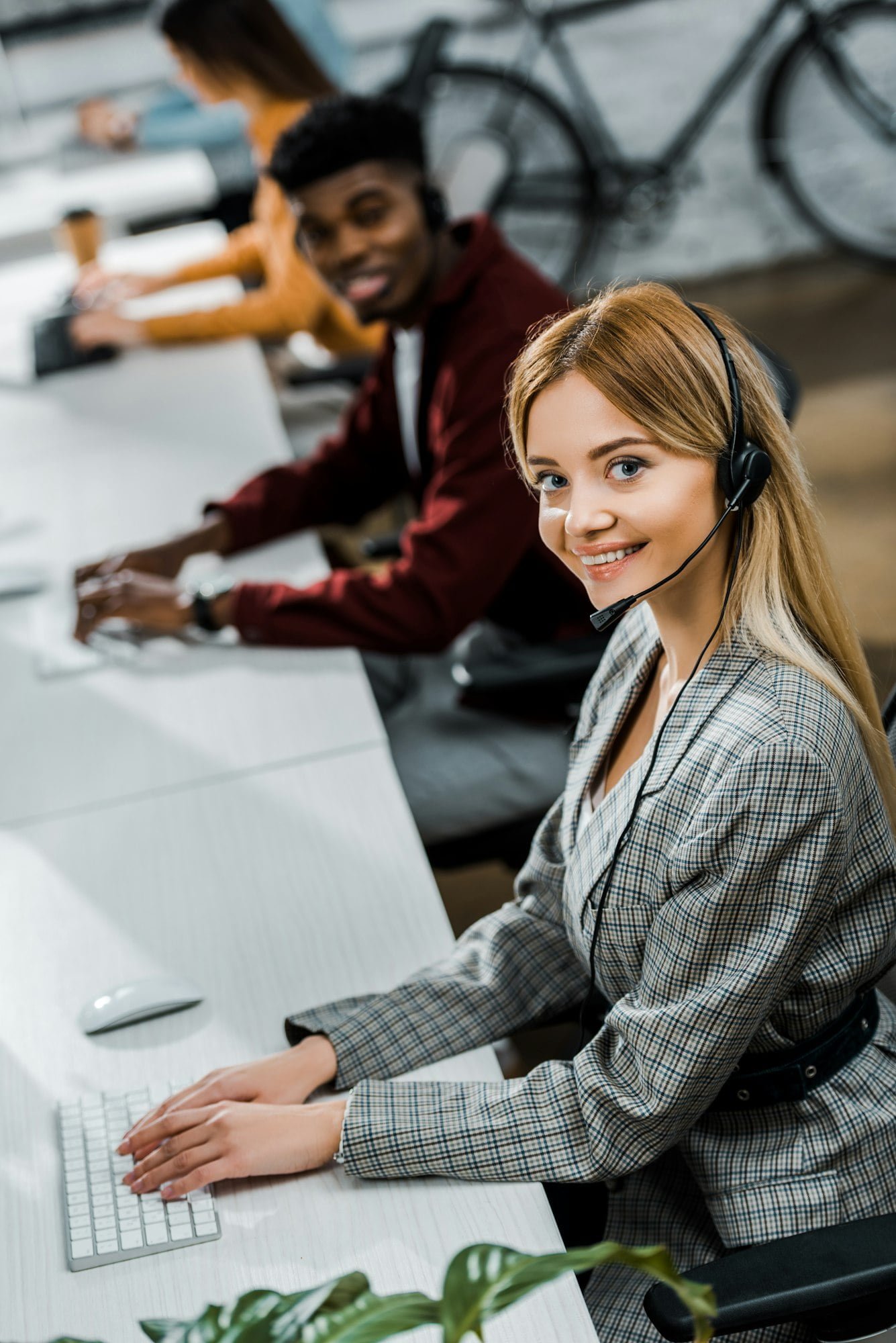 multicultural call center operators with headsets at workpalce in office